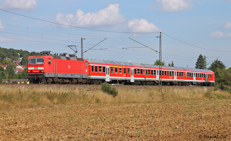 Mit einem aus drei n-Wagen gebildeten Nahverkehrszug ist die Stuttgarter 143 899-3 am 29. August 2012 bei Uhingen auf der Filsbahn unterwegs in Richtung Plochingen.