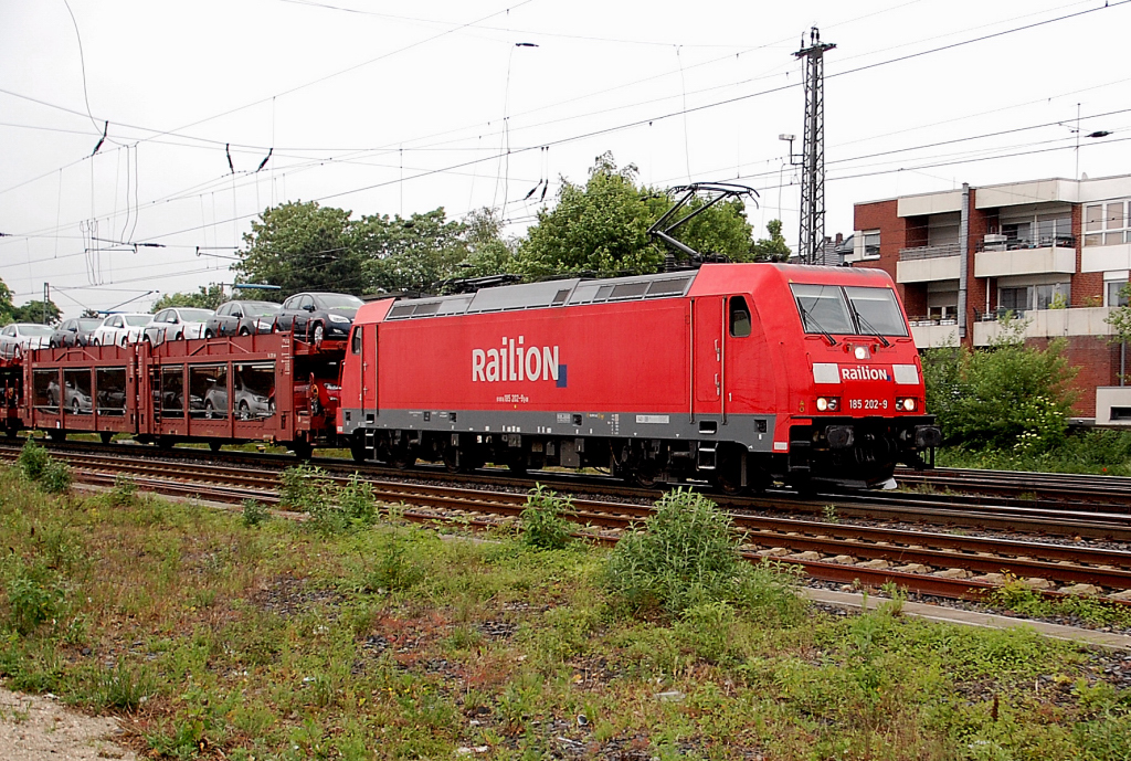 Mit einem Autotransportzug ist die 185 202-9 nach Aachen unterwegs. Hier ist sie in Rheydt Hbf am 16.5.2011