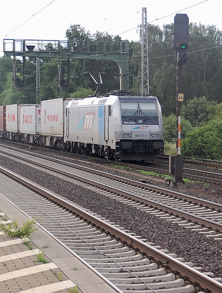 Mit einem Containerzug am Hacken kommt die EBV 185 673-1 aus Seelze in den Bahnhof Dedensen-Gmmer am Morgen des 23.Juni 2011 hineingefahren.