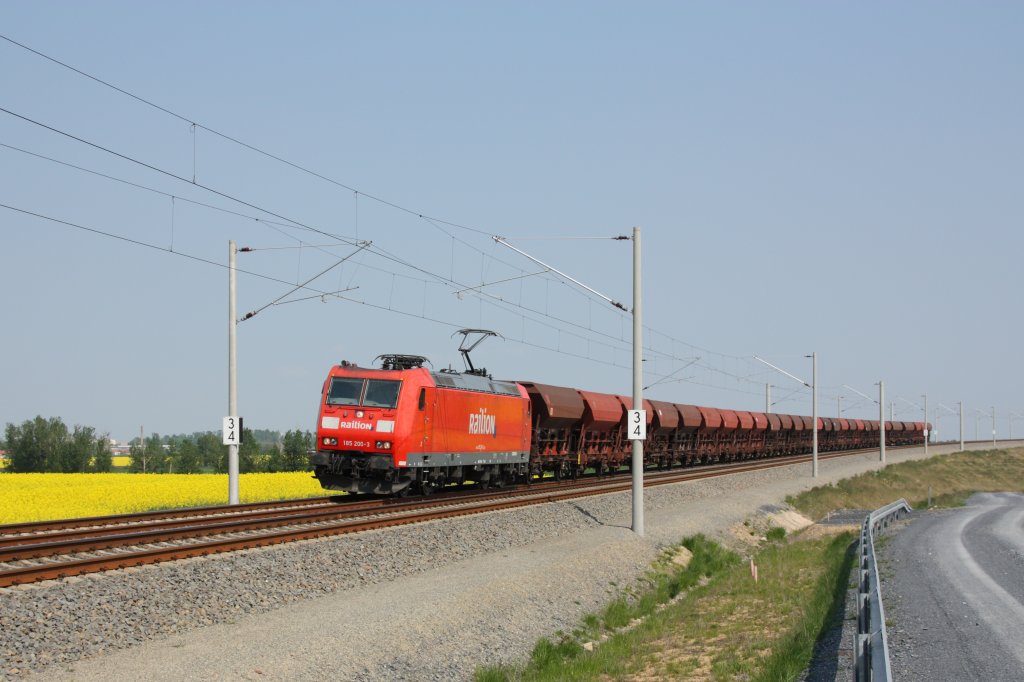 Mit einem Ganzzug Schttgutwagen fhrt 185 200-3 auf der Neubaustrecke zwischen Weiig und Bhla in Richtung Riesa. Fotografiert am 30.04.2011 in Hhe der Ortschaft Strieen. 