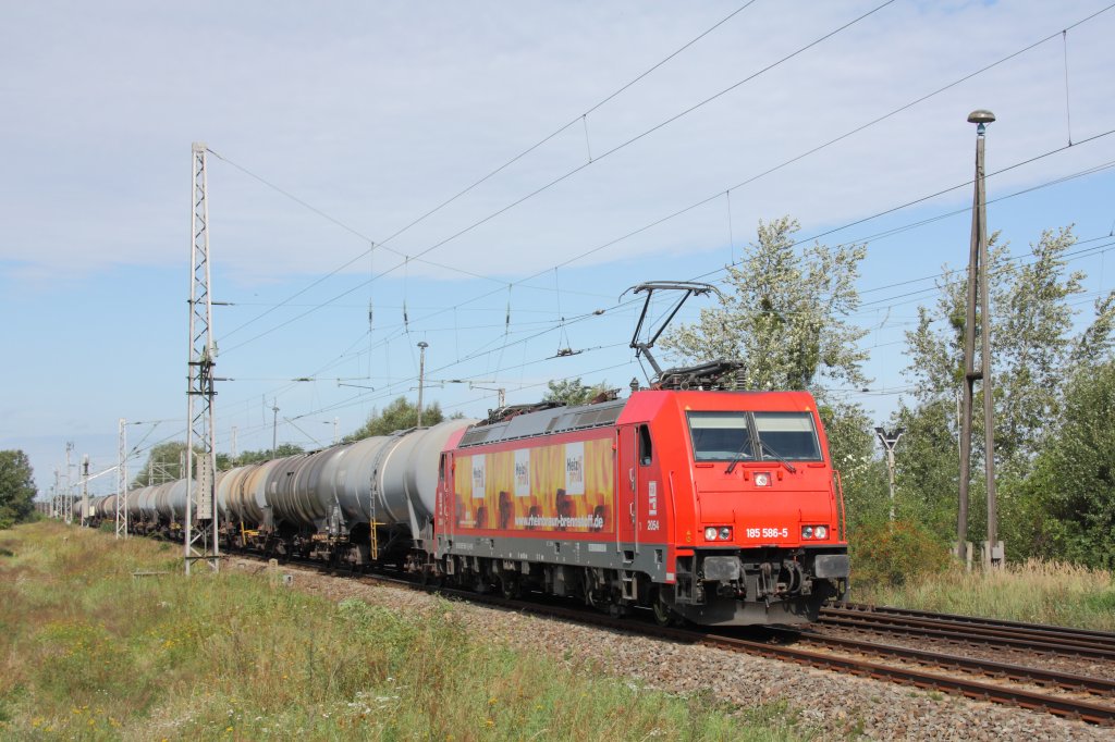 Mit einem Kesselwagenzug fhrt 185 586-5 der HGK (mit Heizprofi-Werbung) aus Richtung Magdeburg kommend durch Knigsborn. Fotografiert am 06.09.2011. 