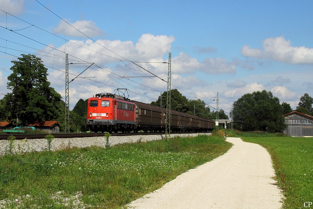 Mit einem kurzen Güterzug ist 140 585-1 am 16.8.2011 nahe dem Ort Übersee unterwegs.