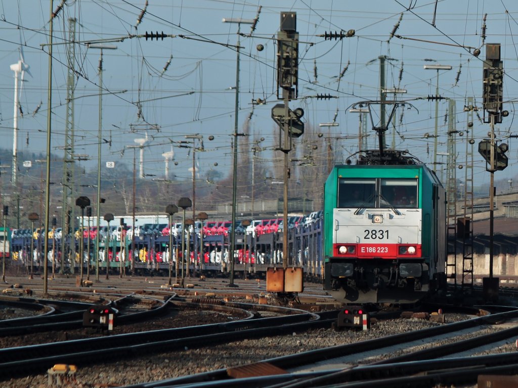 Mit einem mit Opel Astra beladenen langen Autozug am Haken fhrt Cobra 186 223 (2831) am 28.02.2012 aus Aachen West nach Belgien.