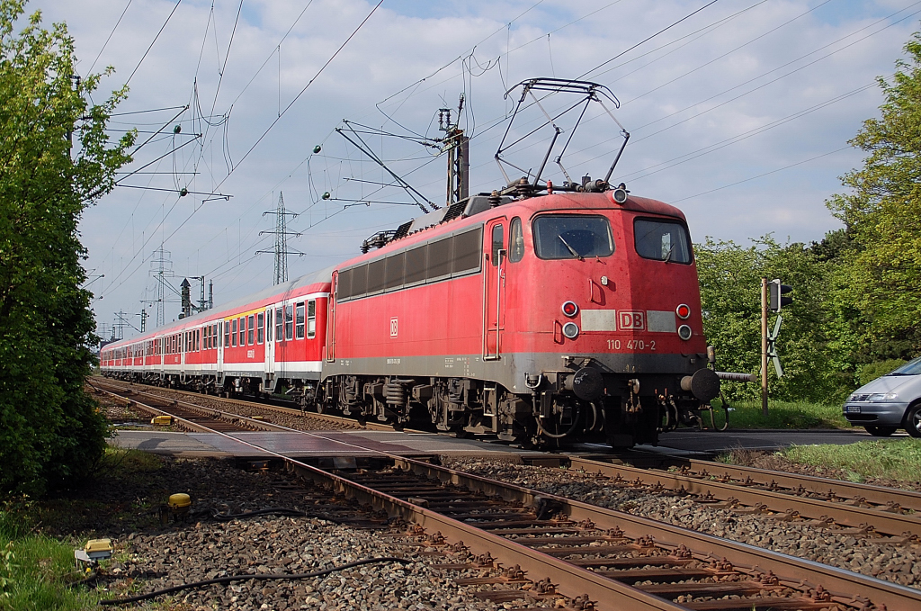 Mit einem N-Wagenzug als Schublok passiert die 110 470-2 den Bahnbergang Hackenbroicher Strae in Worringen. 17.4.2011