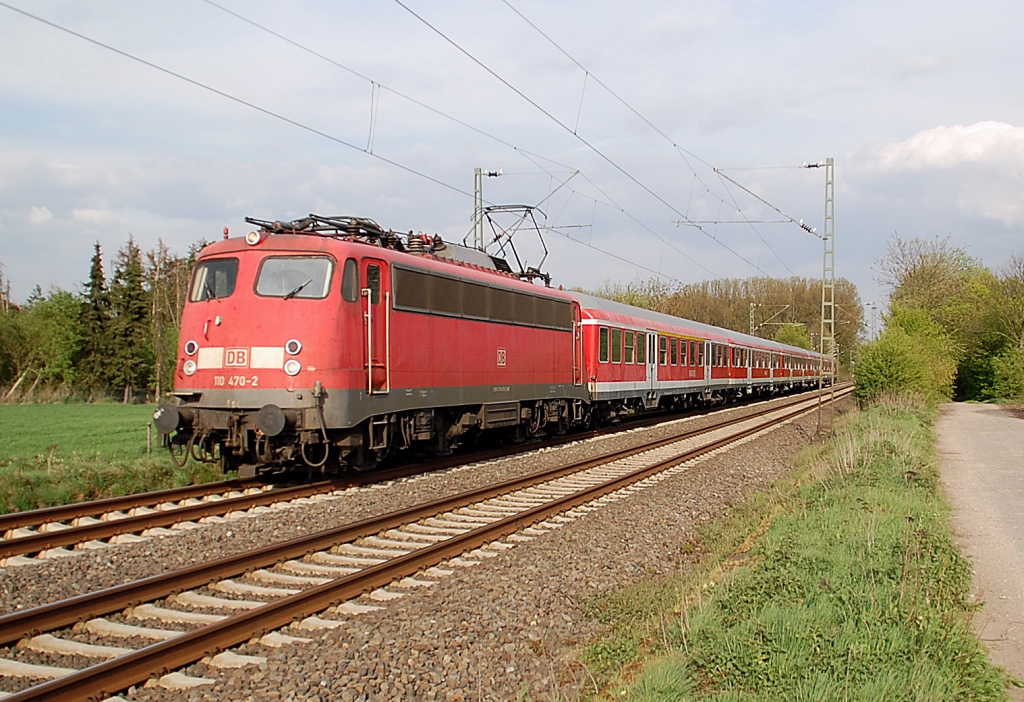 Mit einem RE 4 Verst�rkerzug aus D�sseldorf kommend ist hier die 110 470-2 in Korschenbroich an der Insel zu sehen. 13.4.2011