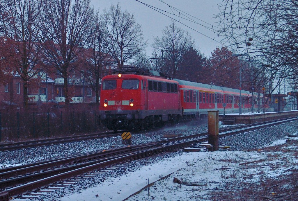 Mit einem RE 4 Verstrkerzug kommt die 110 427-2 an diesem Winterabend durch Korschenbroich gefahren, nchster Halt ist Mnchengladbach Hbf auf ihrem Weg nach Aachen. 14.2.2013