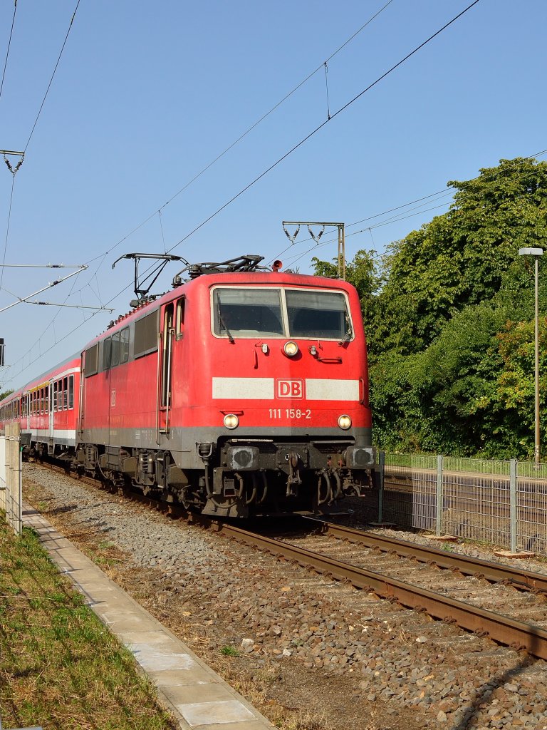 Mit einem RE4 Verstrkerzug in Richtung Aachen hat die 111 158-2 den Bahnsteig in Wickrath verlassen, ihr nchster Halt ist Herrath. Freitag 2.8.2013