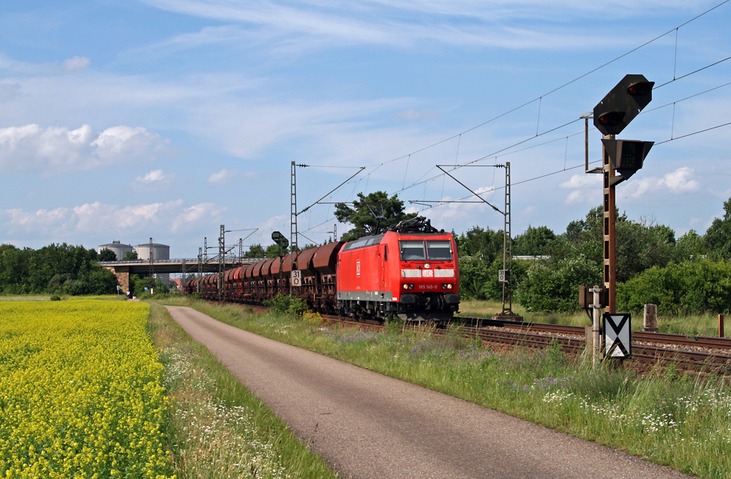 Mit einem sch�nen Schotterwagenganzzug ist die Mannheimer 185 145 am 11. Juni 2010 auf der KBS 700 in Fahrtrichtung Graben-Neudorf unterwegs. Die Aufnahme entstand kurz hinter Wagh�usel.
