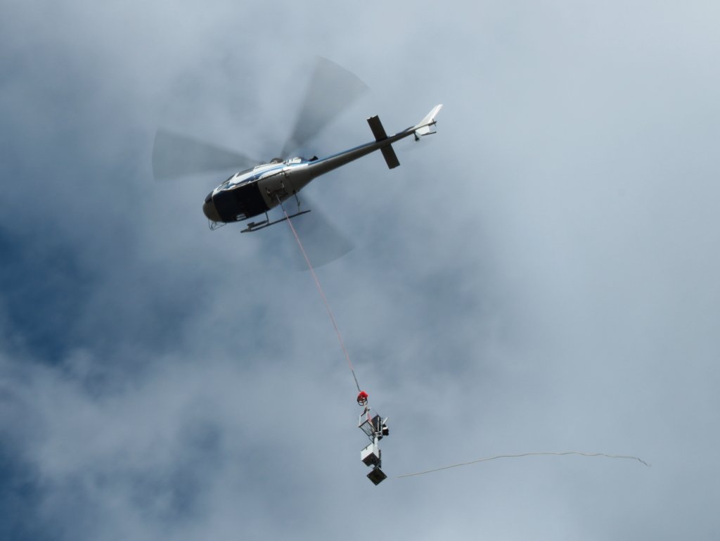 Mit einem Signalmast am Haken fliegt am 07.08.2011 ein Eurocopter AS350 Ecureuil der Firma KMN Koopmann Helicopters in Stolberg vom Lagerplatz zum Hbf.