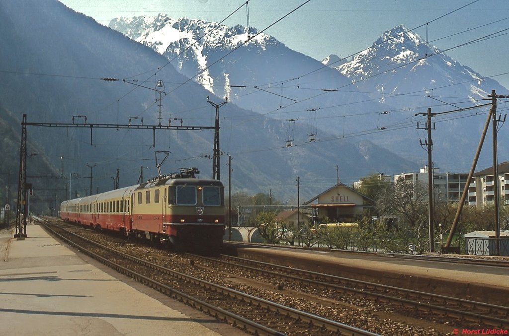 Mit einem TEE nach Milano durchfährt eine Re 4/4 II im Juli 1983 den Bahnhof Martigny
