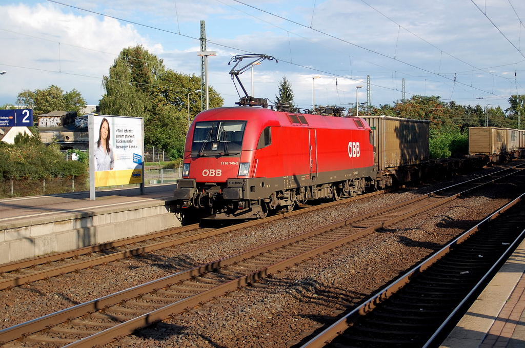 Mit einem Tragwagenzug beladen mit LKW-Ladebr�cken f�hrt hier die �BB 1116 145-2 durch Neuss-Norf am 27.8.2011