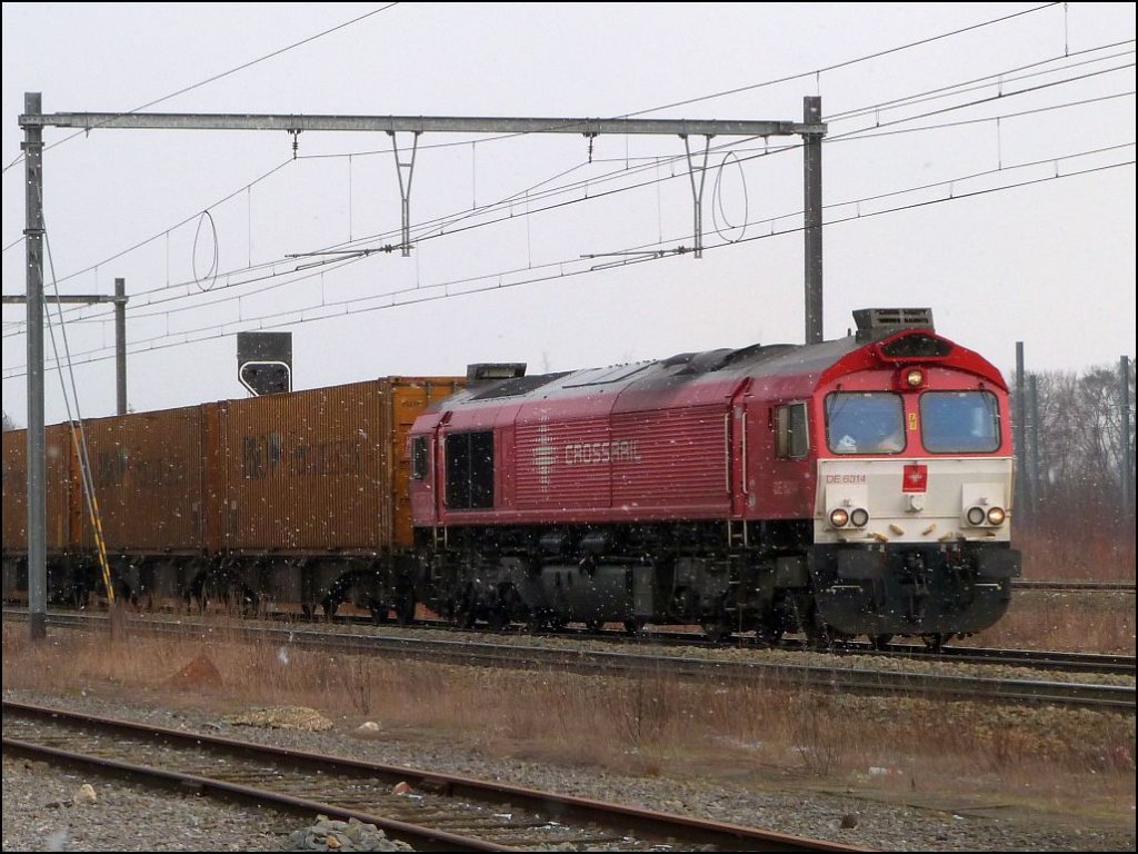 Mit einen Containerzug am Haken ist diese Crossrail Class66 unterwegs auf der 
Montzenroute. Hier bei der Durchfahrt in Montzen Gare am 22.02.2013.
Auch hier waren Schneeschauer heute angesagt.