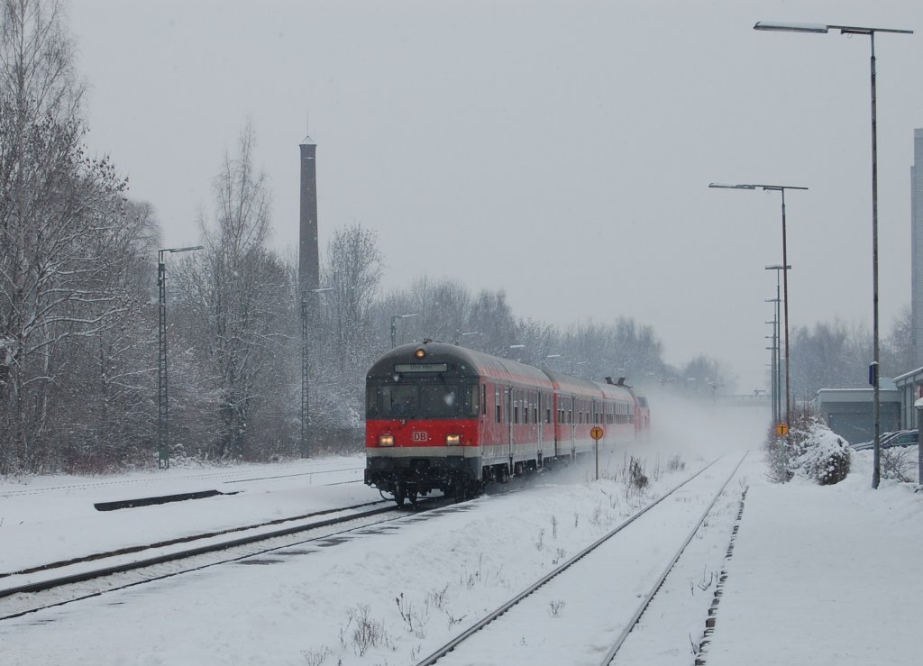 Mit hoher Geschwindigkeit schiebt eine Kemptner 218 ihren Regionalexpress der Linie Ulm - Kempten bei leichtem Schneefall durch den Bahnhof von Senden. Die Aufnahme entstand am 29.12.2010.