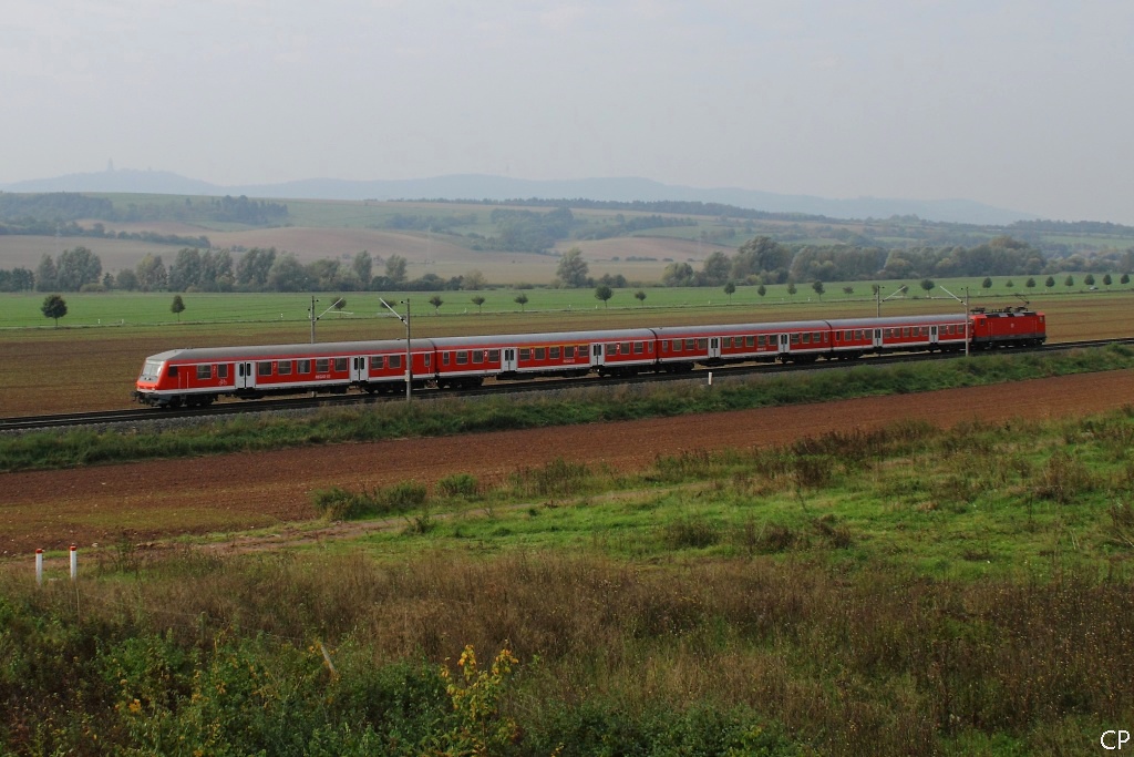Mit leichter Versptung schiebt eine leider unerkannt gebliebene 143 den RE 26135 am 1.10.2010 Sangerhausen entgegen. Im Hintergrund erhebt sich der Kyffhuser, links im Bild lsst sich auch das bekannte Denkmal erahnen.
