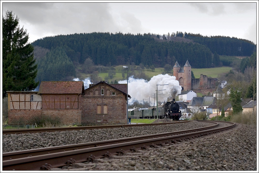 Mit rund 5 Minuten Versptung war am 5.4.2010 38 2455 mit ihrem Sonderzug 37895 von Trier nach Gerolstein unterwegs. Die Aufnahme entstand bei der Durchfahrt in Mrlenbach mit der Bertradaburg im Hintergrund.