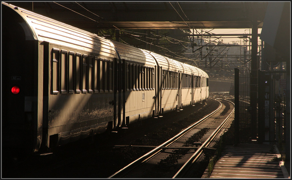 Mit Schlusslicht und Schatten - 

Zug-Durchfahrt am frühen Morgen im Bahnhof La Garenne-Colombes. 

23.07.2012 (M) 