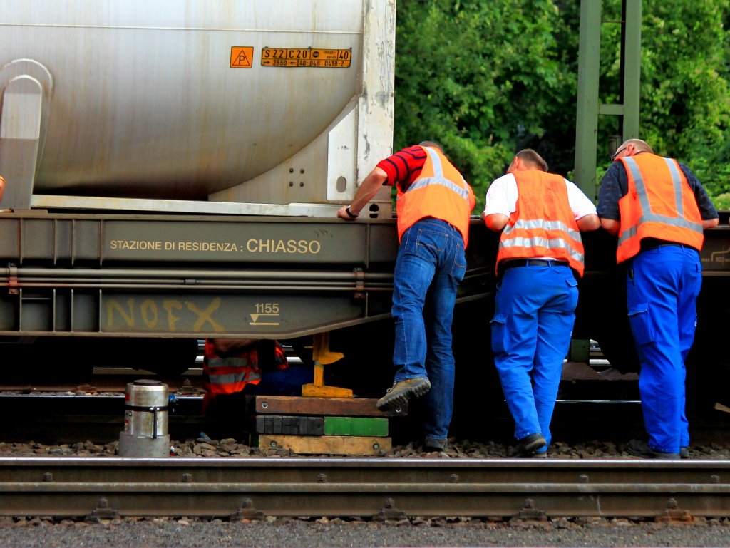 Mit einer Stockwinde und viel Muskelkraft wird am 22.08.2012 in Aachen West der verrutschte und in Schrglage hngende Container auf dem Taschenwagen angehoben und in eine Position gebracht um ihn wieder gerade auf den Wagen zu stellen. In der Nacht ist dort ein Sdgmns der HUPAC bei der Einfahrt in Aachen West an einer Weiche entgleist. Ob der Container schon vor oder erst durch die Entgleisung verrutscht und in Schrglage geraten ist wird nun untersucht.