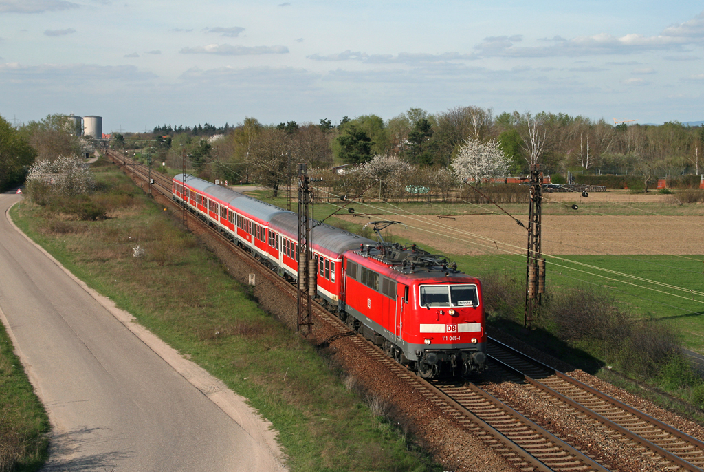 Mit der verspteten RB 18691 von Mannheim nach Karlsruhe am Haken erreicht die Ludwigshafener 111 045 am Abend des 09. April 2010 in wenigen Augenblicken den Haltepunkt von Wiesental.
