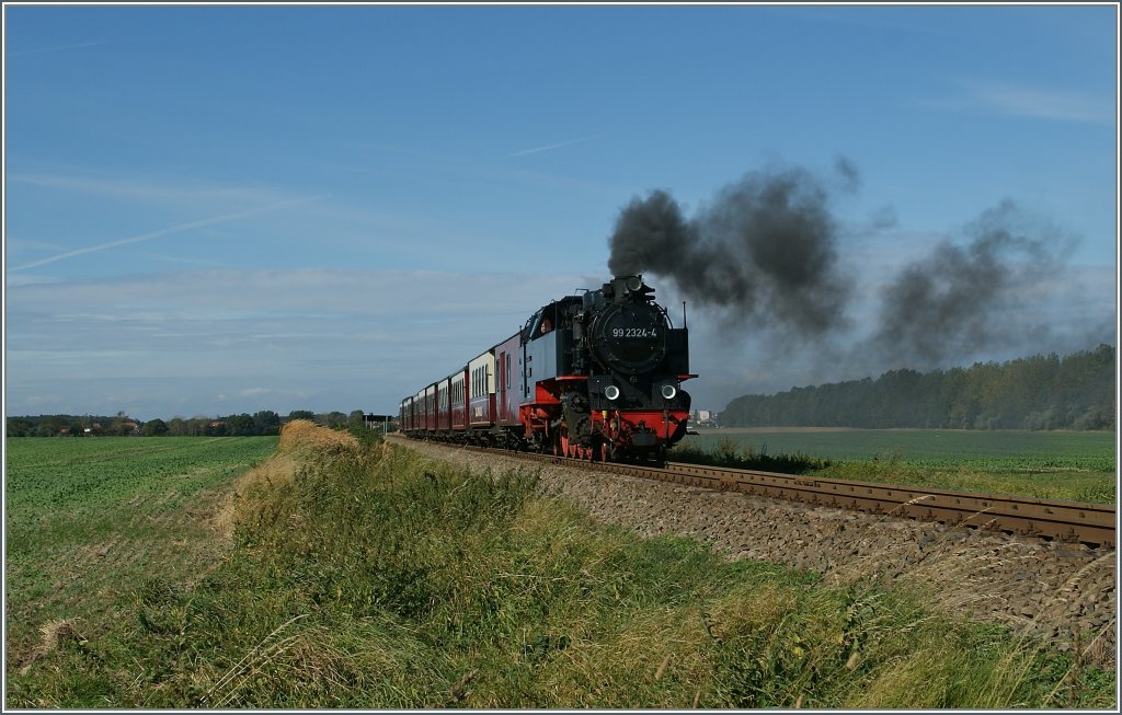 Mit Volldampf fhrt die 99 2324-4 mit ihrem langen Zug Richtung Bad Doberan.
Da Bild entstand am 20. Sept. 2012 kurz vor der Haltestelle  Steilkste .