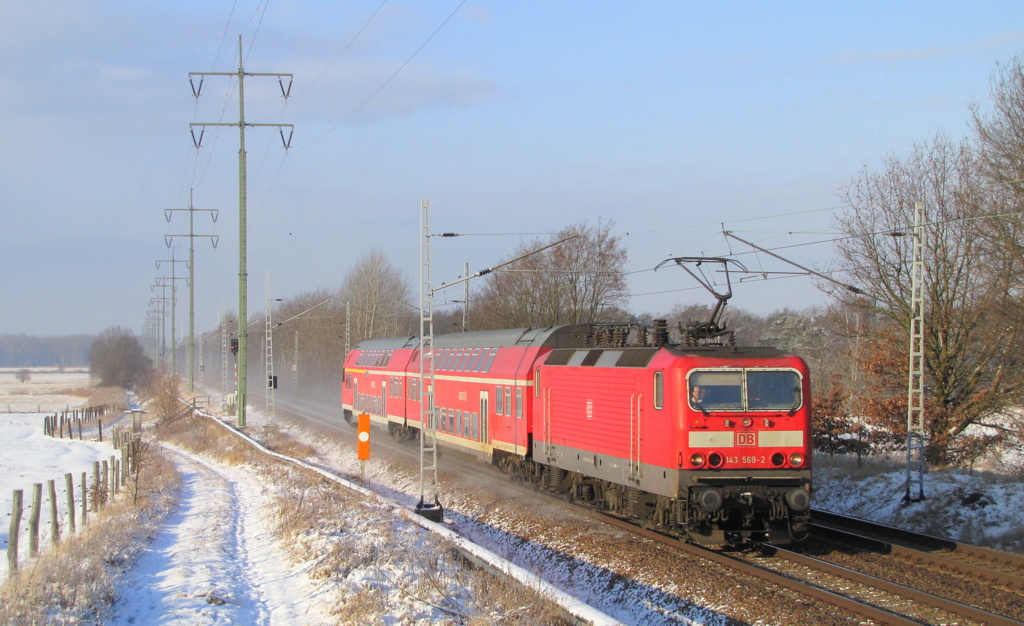 Mit vorderem gehobenen Stromabnehmer dst hier die RB22 nach Berlin Schnefeld Flughafen durch Diedersdorf. Als Lok dient 143 569-2. 03.02.2012 