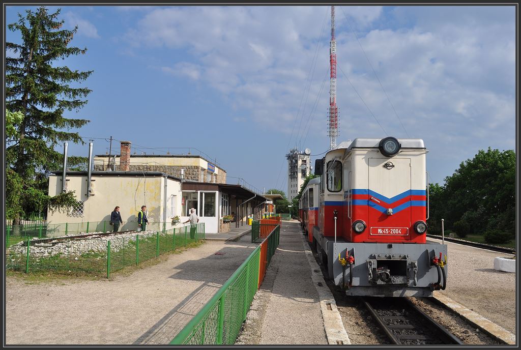 MK45-2004 der Gyermekvast/Kindereisenbahn in Szchenyi-hegi mit Bhanhof und TV-Turm im Hintergrund. (11.05.2013)