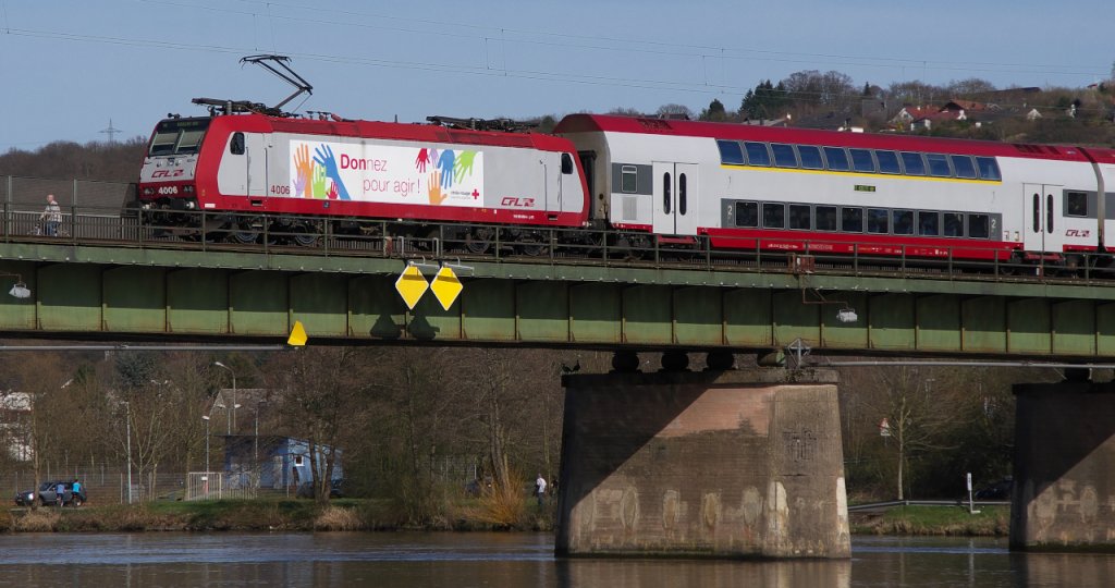 Mosel abwrts wird er gleich fahren, der RE aus Luxemburg nach Koblenz. Hier bei Konz berquert der Zug mit CFL 4006 die Mosel. ber Karthaus und Trier wird es weiter in Richtung Koblenz gehen. Die Moselbrcke in Konz ist die Verbindung der Trierer Weststrecke mit der Saarstrecke und der Obermoselstrecke. CFL 4006 trgt Werbung fr das Rote Kreuz in Luxemburg. 14.04.2013 bei sonnigen 24C am Mosel Ufer. KBS 693 Moselbrcke Kreuz Konz - Karthaus