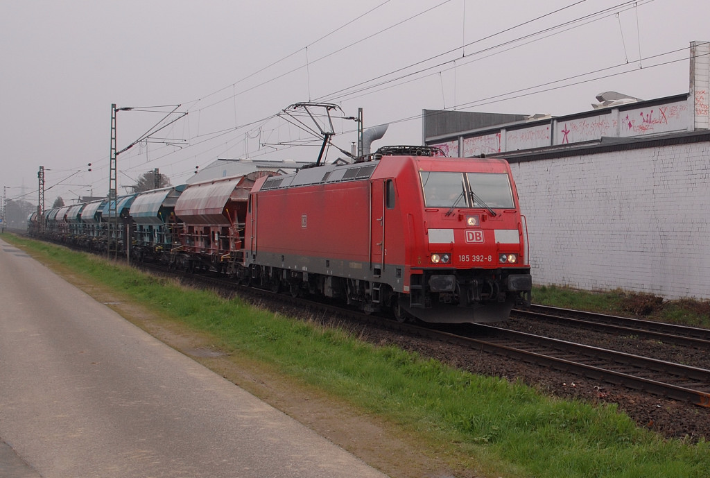 Na am Bahnbergang Lerchenfeldstrae in Anrath kommt die 185 392-8 mit belgischen Silowagen vorber gefahren am 14.4.2012
