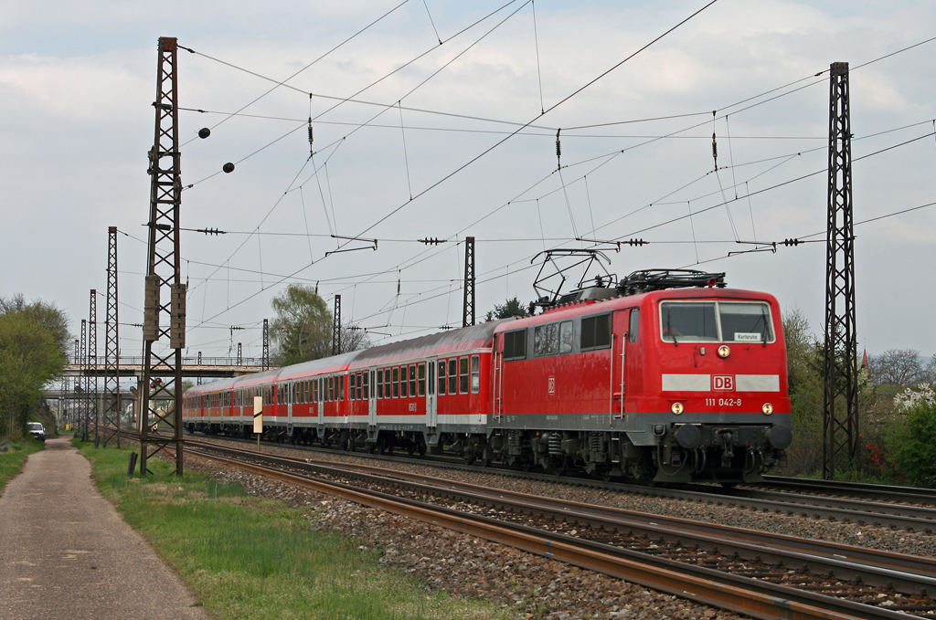 Nach dem Zwischenhalt in Oftersheim bringt die Ludwigshafener 111 042 am 16. April 2010 die versptete RB 18621 von Mannheim nach Karlsruhe wieder auf Hchstgeschwindigkeit.
Der nchste Halt des Zuges ist der Bahnhof von Hockenheim.