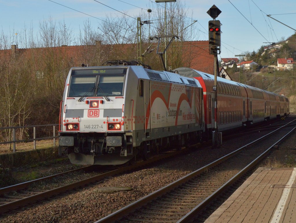Nach Ulm fahrend kommt die 146 227-4 mit einer RB an den Bahnsteig in Neckarzimmern am 29.12.2012 herangefahren.