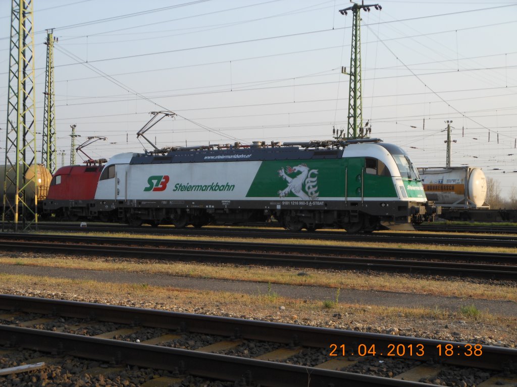 Nachdem die Siemens-Mehrsystemlokomotive 1216 960-5 der Steiermarkbahn vor meinen Augen mit einem G�terzug durch den Bahnhof Gramatneusiedl Richtung Osten gefahren war, sagte mir meine langj�hrige Erfahrung als  Taurusj�ger , da� sie vermutlich knapp hinter der Grenze zu finden sein m��te. Ich sollte mich nicht get�uscht haben: nach einem ziemlich forschen Ritt �ber die Autobahn traf ich das Fahrzeug kurz vor seiner R�ckkehr nach �sterreich auf dem Frachtenbahnhof in Hegyeshalom an (Aufnahme vom 21.4.2013).