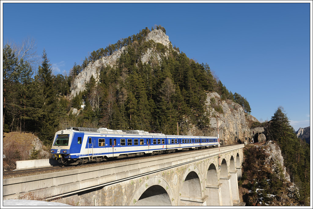 Nachschuss auf 4020 304, am 25.2.2012 als R 2964 von Semmering nach Payerbach-Reichenau unterwegs,  aufgenommen bei der Querung des 87 Meter langen und 36,5 Meter hohen Krauselklause-Viadukt mit dem 13,55 kurzem Krausel-Tunnel im Hintergrund.