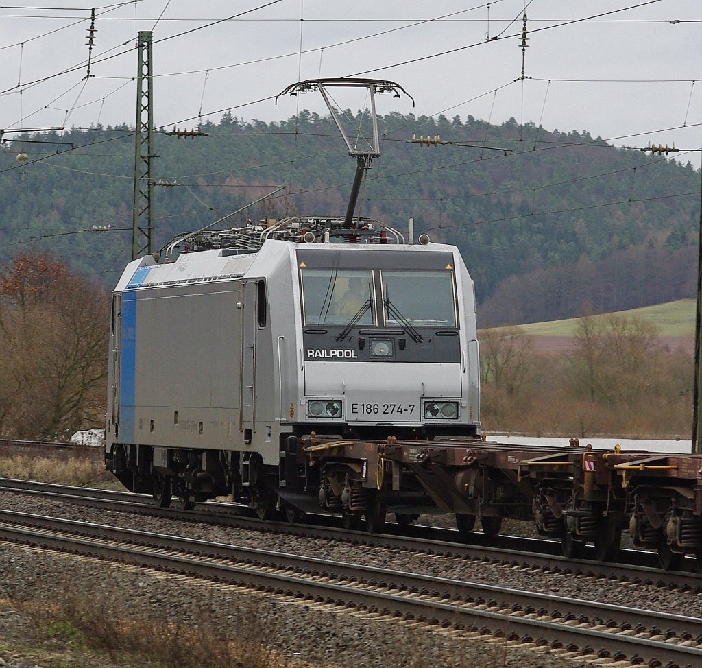 Nachschuss ber den leeren Flachwagen hinweg auf 186 274-7 aus dem Railpool. Aufgenommen am 15.01.2011 in Mecklar.