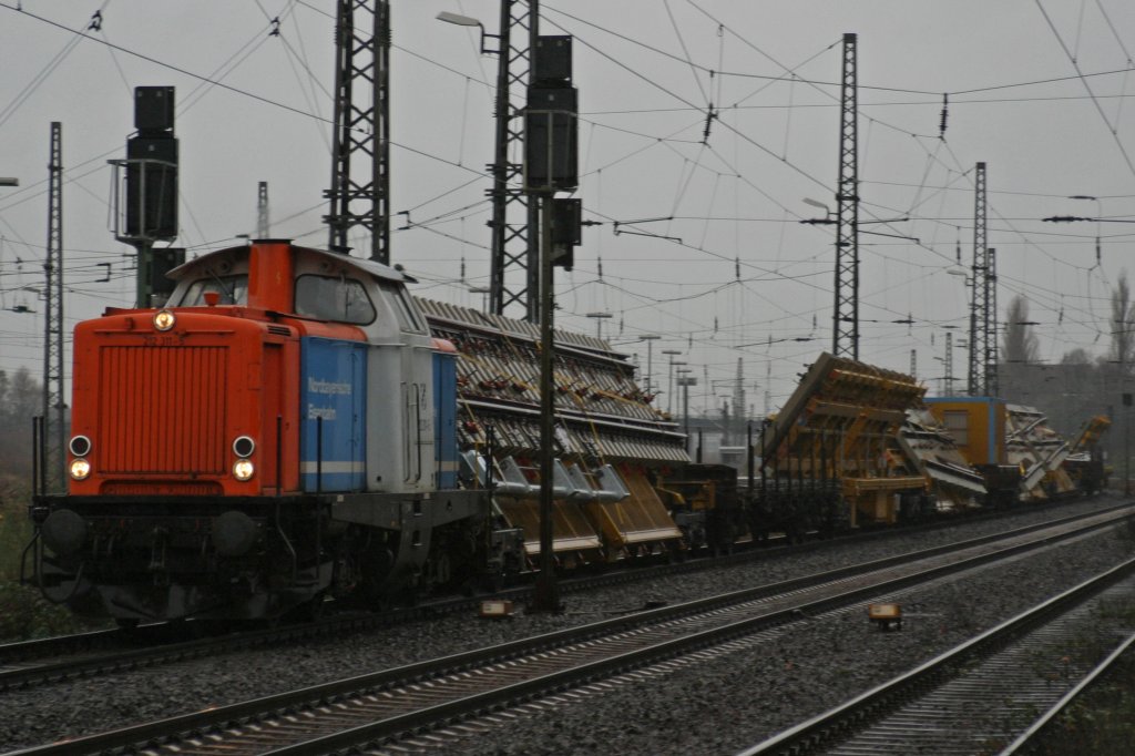 NbE 212 311-5 durchfhrt am 28.11.09 im strhmende Regen mit einem Bauzug Duisburg-Bissingheim
