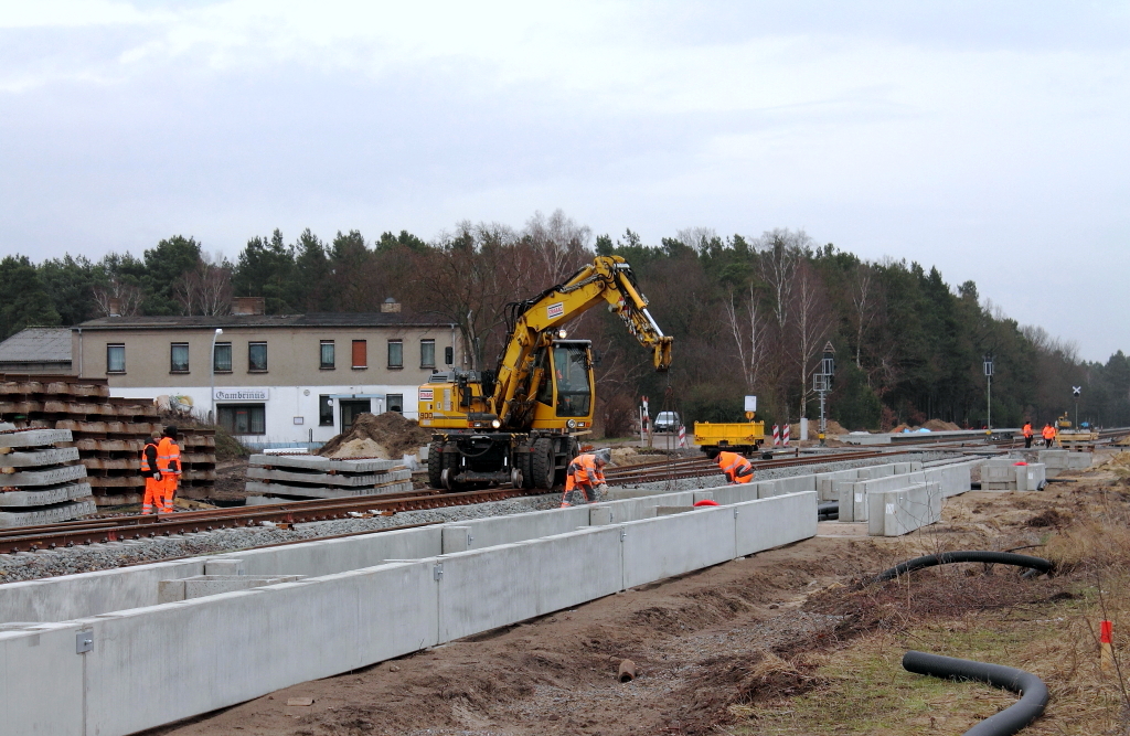 Neues von der Baustelle in Nassenheide am 01.02.2013. Im Vordergrund der teilmontierte Bahnsteig Richtung Berlin, in der Mitte werden mittels Zwei-Wege-Baggers der Fa. Strabag Betonschwellen verlegt und im Hintergrund der Bahnsteig Richtung Stralsund/Rostock. Die versetzte Anordnung der Bahnsteige und ohne EG, das ist schon gewhnungsbedrftig.