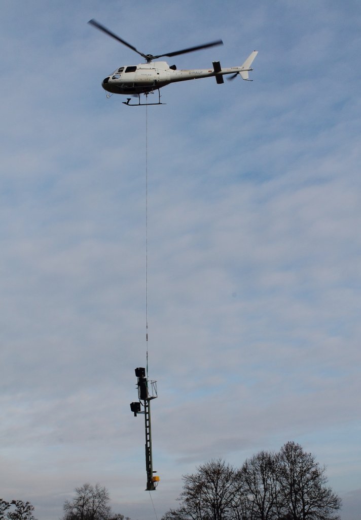 Neues von der Baustelle in Nassenheide am 22.11.2012 Teil 1. Ein Hubschrauber der Fa. Thales mit einem Signal am Haken beim Anflug zum Einbauort Gleis 1 am Streckenkilometer 34,707 der Nordbahn.

