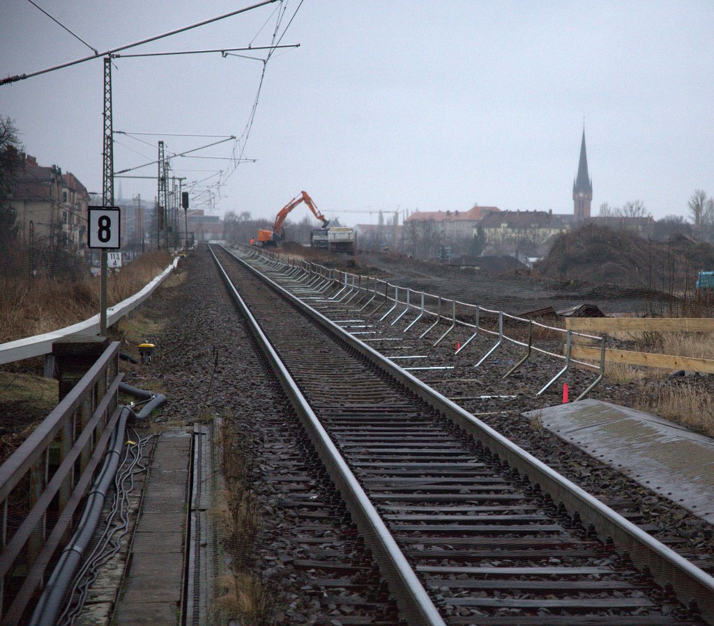 Nieselgrauer M�rztag, der Fotograf  wartet auf einen Zug der Linie S1 aus Dresden nach Radebeul und versucht gegen 15:05 Uhr das Baugeschen - hier Altschotterverladung auf LKW - auf das Bild zu bannen. 
Ein lichtstarkes Tele w�re sicher das bessere Objektiv, als das  alte Canon 24-85.
