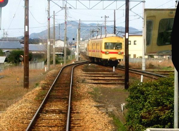 Nishitetsu-Konzern, Kaizuka-Linie (1067mm-Spur): Der älteste Zug 305/355 von 1948 bei der Einfahrt in Koga, 16.März 2007. Der im Bild sichtbare Streckenabschnitt wurde nur einige Tage nach dieser Aufnahme stillgelegt; gleichzeitig wurde dieser älteste Zug des Wagenparks sofort verschrottet. 
