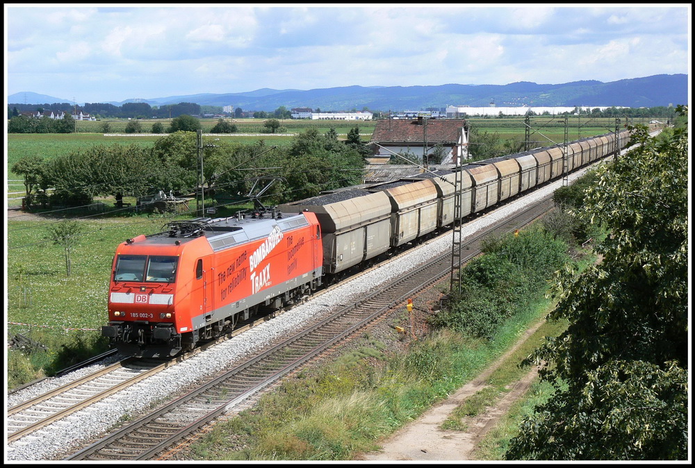 Noch mit Traxx-Werbung passiert die 185 002 meine Fotostelle bei Ladenburg mit einem Kohlezug aus PKP-Wagen. 30.7.2007