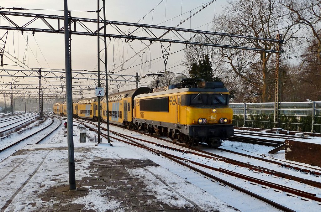 NS E 1715 zieht die Doppelstockwagen mit Schnellzug Hoorn - Den Haag CS, hier bei Einfahrt von Haarlem Hbf am 03.12 2010.