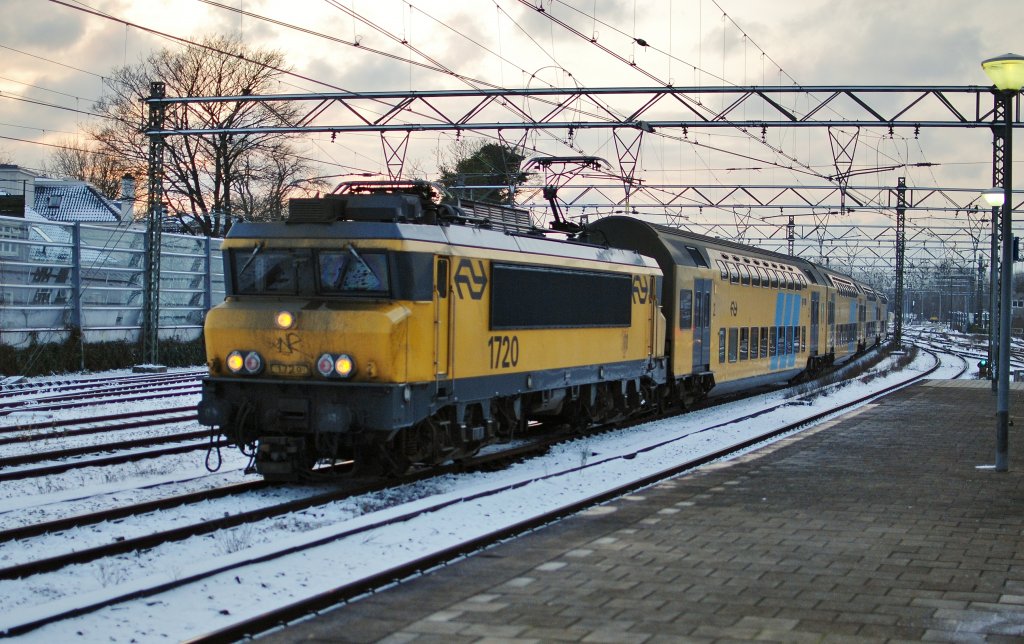 NS E 1720 zieht die Doppelstock mit Regional UItgeest - Amsterdam Centraal, hier bei Einfahrt von Bf Haarlem am 30.11 2010.