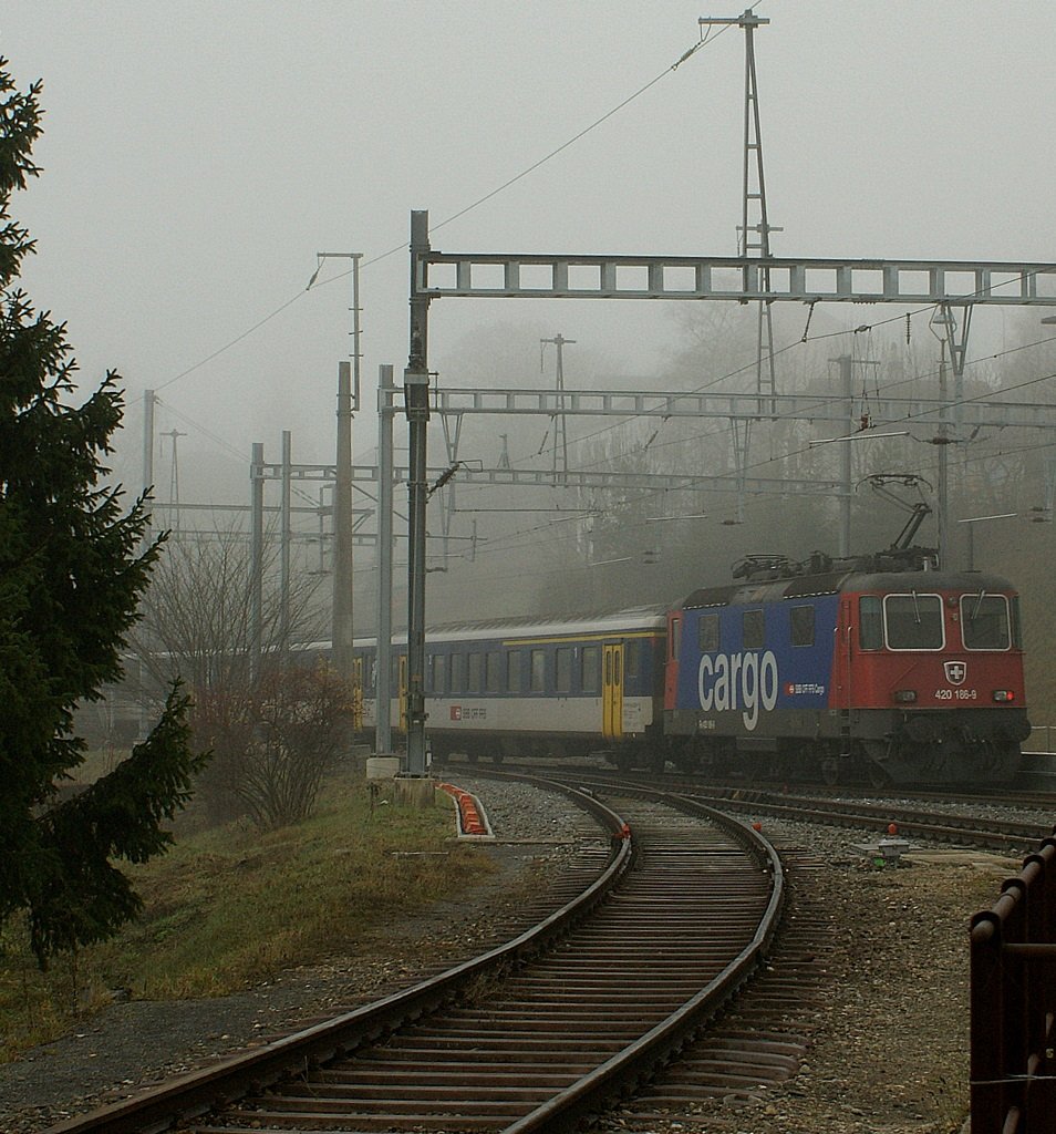 Nun weiss ich, dass auch Juratäler neblig sein können und SBB Cargo Re 4/4 II auch Pendelzüge traktieren: Regionalzug 4814 bei der Ausfahrt in Travers Richtung Fleurier am 19. November 2009
