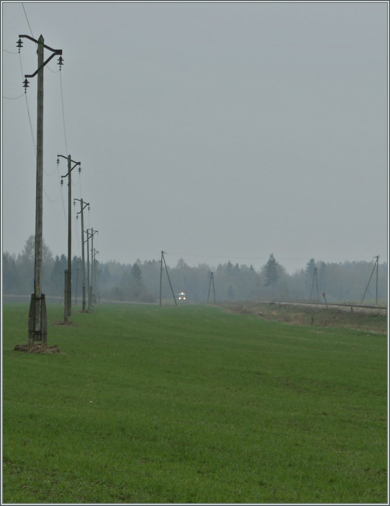 Nur drei winzige Licht-Punkte machen dieses Foto zum Bahnbild: Der Edelaraudtee Dieselriebzug 0231 von Ralpa nach Tallinn kurz nach Rapla am 5. Mai 2012