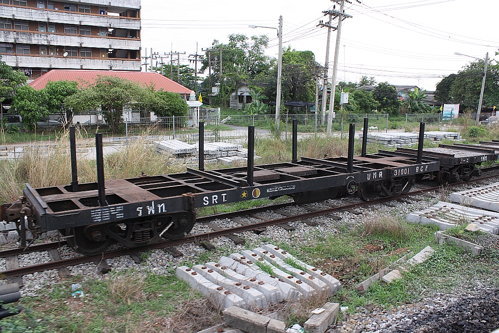 Obwohl zu einem Rungenflachwagen umgebaut, behielt der บ.ท.ต. 31001 (บทต = B.C.F./Bogie Container Flat Wagon) seine alte Bezeichnung und Fahrzeugnummer. Chachoengsao Junction am 17.März 2011.