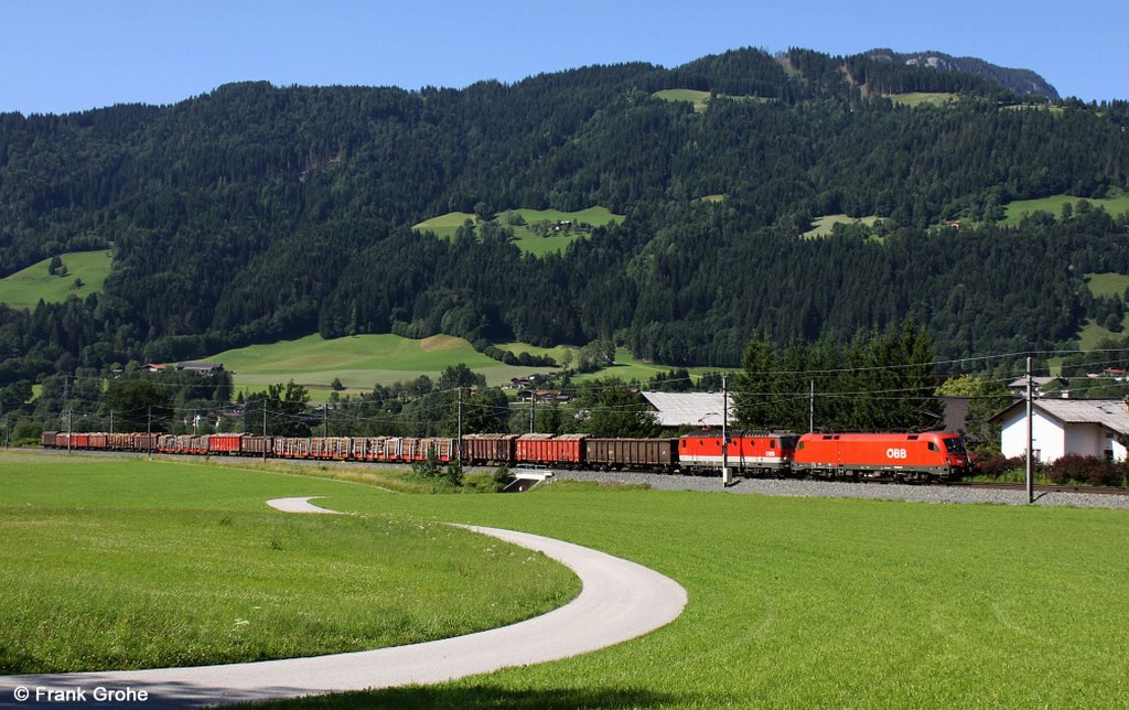 BB 1116 281-5 + 1144 239-1 mit Gterzug Holztransport Richtung St. Johann in Tirol, Salzburg-Tiroler-Bahn KBS 201 Innsbruck - Saalfelden, fotografiert zwischen Brugghusl und Bruggberg am 27.07.2011