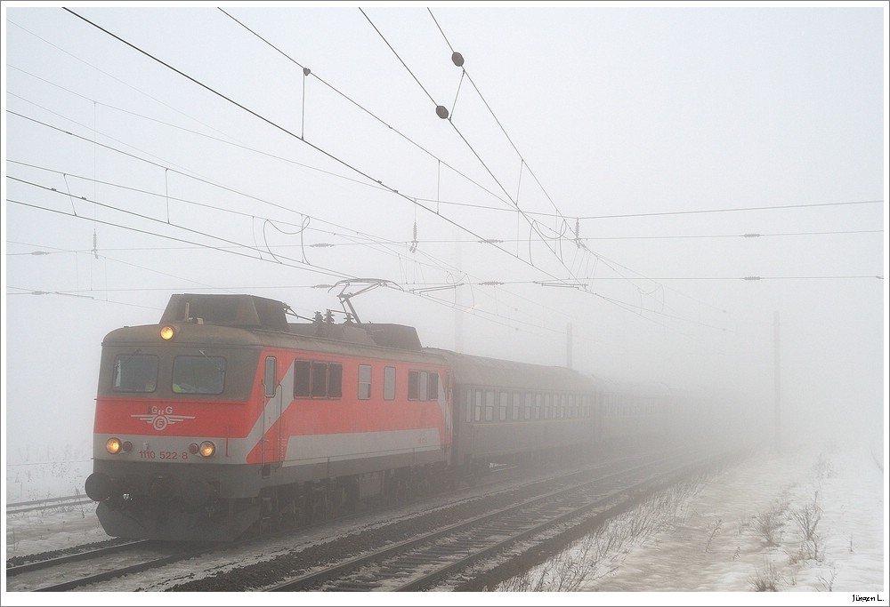 GEG 1110.522 mit dem  Dampfsonderzug  R14387 von Wien/Meidling nach Bratislava. Leider hat's die fr diesen Zug geplante 52.7612 nur bis Wien/Handelskai geschafft, sodass die 1110 den Zug alleine bernommen hat; aufgenommen irgendwo im Nebel; 8.12.2010.