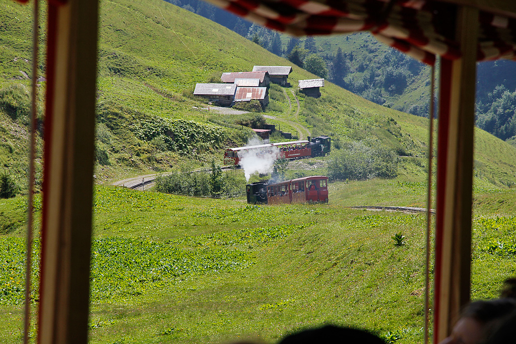 lbefeuerte Lok16 mit Panoramawagen und kohlenbefeuerte Lok6 mit Wagen B16 + B26 fahren talwrts Richtung Planalp. Aufnahme in der Chemad vom nachfolgenden Salon Rouge-Zug aus. 16. Juli 2011, 15:00