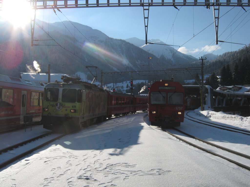 Parallelleinfahrt zweier Zge in Klosters. Links: Ge 4/4 II 611 Login mit RE 1228 (ca. 4 min. zu Spt), rechts: BDt 1757 mit Ge 4/4 III in der Zugsmitte als RE 1028. Auf Gleis 1 steht noch ein Allegra mit dem RE nach Davos Platz, 22.01.2011.