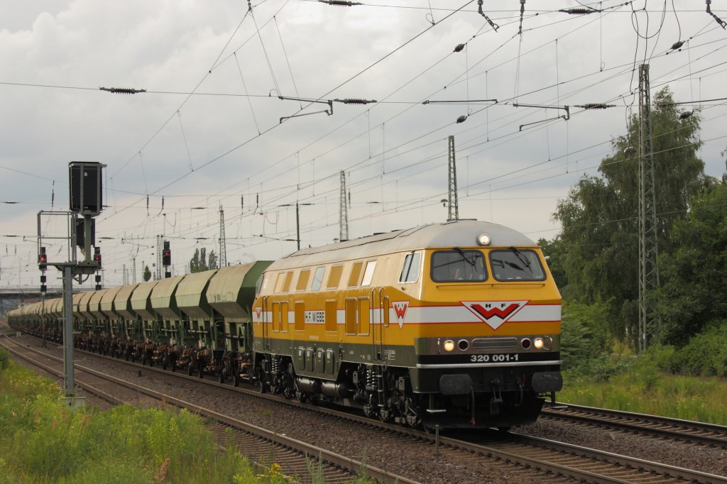 Passend zum Ergebnis der Deutschen Nationalelf vernderte sich auch das Wetter... Am Abend des 18.06.2010 bestimmten graue Wolken den Himmel ber Schnebeck (Elbe). Auf den Schienen gab es jedoch einen Farbtupfer in Form von 320 001-1 der Firma H.F. Wiebe mit einem Langen Ganzzug Selbstentladewagen. Der Zug kam aus Richtung Magdeburg. 