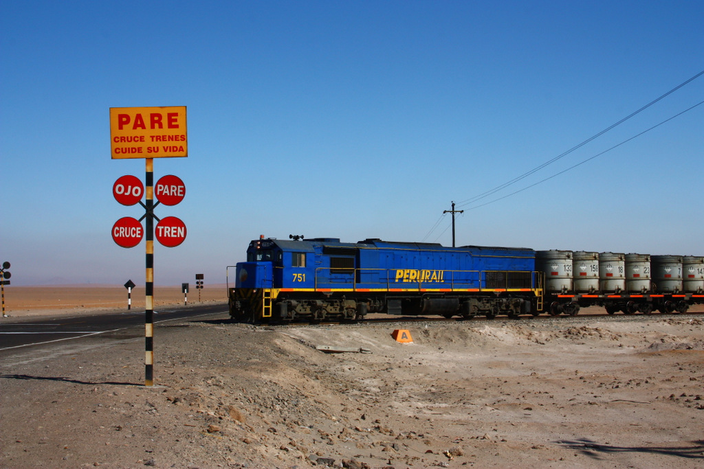 PERURAIL 751 berquert die Panamericana Sur auf dem Altiplano in Sdperu. Der Zug kommt vom Hafen Matarani, wo er mit Sure fr die Kupferminen beladen wurde. Er ist kurz vor seinem Ziel La Joya, wo die Behter auf LKW umgeladen und zu den einzelnen Minen gebracht werden. 28.08.2011 

