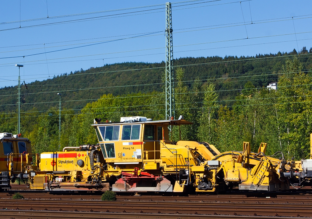 Plasser & Theurer Schnellschotterplaniermaschine SSP 110 SW   Ploeg 14  (Schweres Nebenfahrzeug Nr. 97 16 46 509 18-4)  der Niederl�ndischen Fa. Strukton Rail b.v. mit einer Niederlassung in Kassel, abgestell am 08.09.2012 in Betzdorf/Sieg. Die Maschine wurde 2004 unter der Maschine-Nr. 758 gebaut.   

Techn. Daten:  Gesamtl�nge �ber Puffer 17.050 mm  >  Anzahl der Achsen 2  >  Gewicht 44.000 kg  >  Max. Eigenfahrgeschwindigkeit 100 km/h   >  Leistung 400 kW  (Deutz BF8M 1015C Motor)  >  Spurma� 1.435mm  >  zugelassen f�r Streckenklasse D2 oder h�her.

Schotterpfl�ge werden vor oder nach dem Stopfen des Gleises eingesetzt. Die Maschinen bewirken eine optimale Schotterverteilung und Formen das Profil des Schotterbettes. Dies ist notwendig f�r den Seitenwiederstand des Schotterbettes.